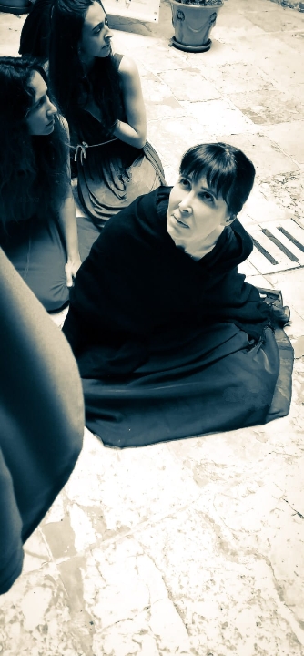 "Las troyanas" de Eurípides. Representación al aire libre. Actriz sobre el suelo, compungida, representando a una troyana de la obra de Eurípides "Las troyanas".