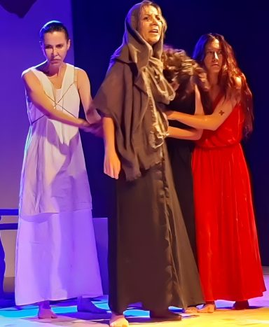 "Las troyanas" de Eurípides Actriz sobre el suelo, compungida, representando a una troyana de la obra de Eurípides "Las troyanas".