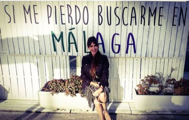 Como no, en Málaga tenía que ser. Moira Láquesis con una pintada de fondo que pone "Si me pierdo buscadme en Málaga"